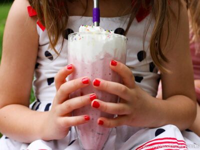 little girl holding milkshake